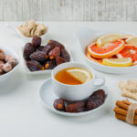 tea with ginger cinnamon sticks citrus fruits dates nuts cup